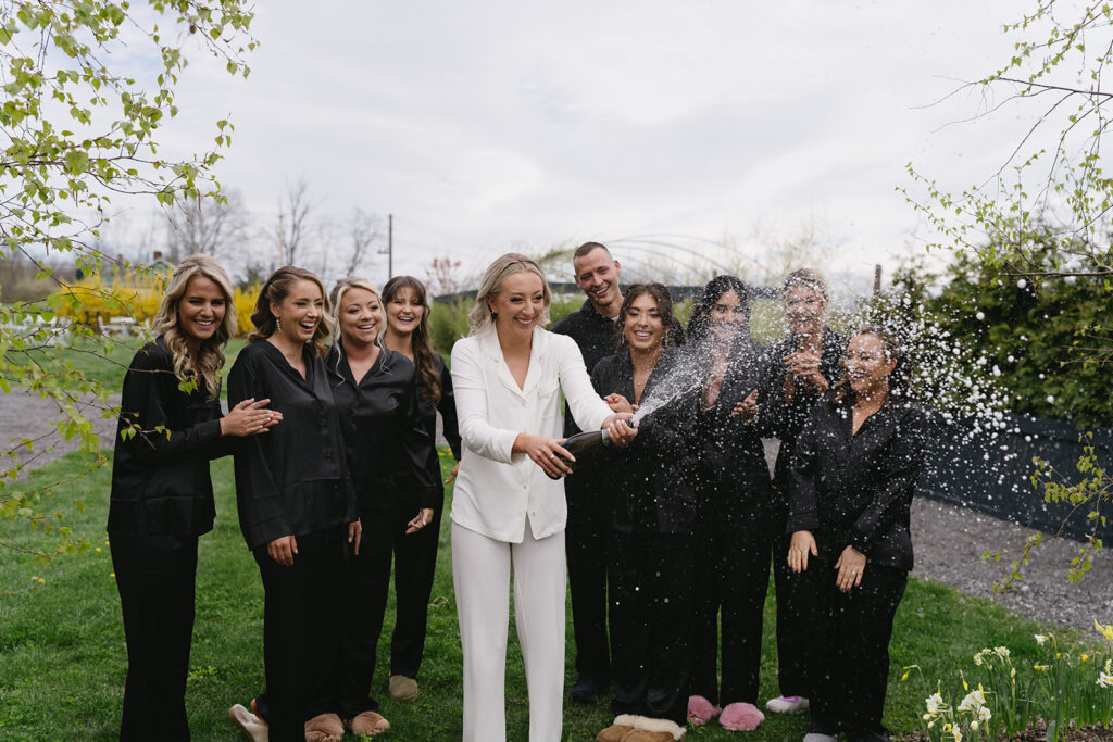 Bridal Party popping the champagne bottle the morning of the wedding