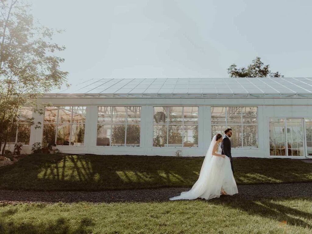 Newlywed couple walking on a gravel path during sunset. 