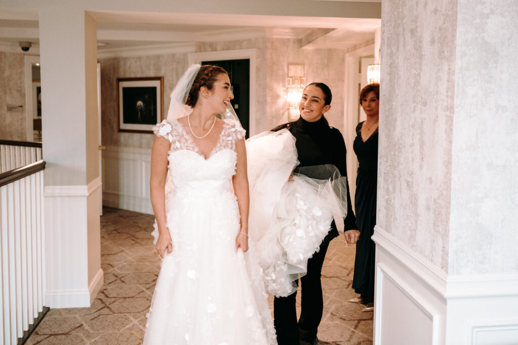 Kelly Jeanmaire, luxury wedding planner of the Main Event by Kelly was holding a bride's wedding train. This is one of the things wedding planners do on a wedding day.