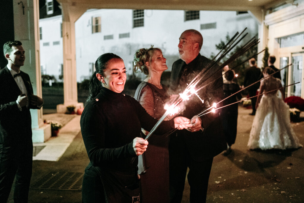 Wedding planner Kelly lighting a wedding spakler at the end of the night on a wedding at the Glen Sanders Mansion in Schenectady NY. One of the things wedding planners do on a wedding day