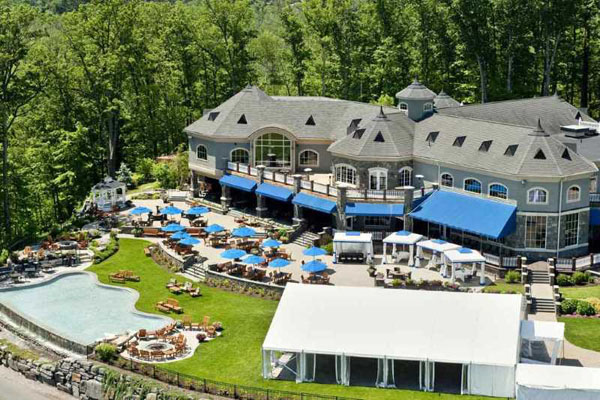 a Aerial view of the Saratoga National Golf Club, set up with a patio and a tent that host weddings. One of our favorite Saratoga wedding venues!