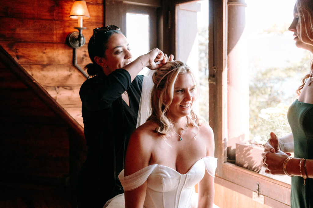 Do You Need A Wedding Planner? Kelly putting a veil on her bride Laura at the Lake George club during a wedding