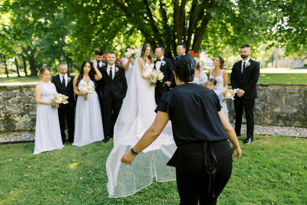 Luxury Wedding Planner Kelly Jeanmaire laying a veil flat during wedding photo